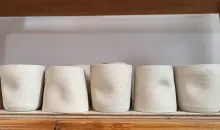 Ongebakken bekers op de plank om te drogen